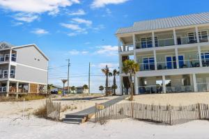 una casa en la playa junto a un edificio en Just Beachy by Pristine Properties Vacation Rentals, en Mexico Beach