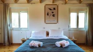 a bedroom with a bed with two towels on it at Villa Voleonas-private pool & olive grove Chania in Kounoupidhianá