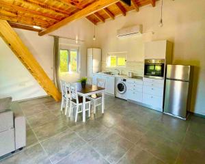 a large kitchen with a table and a refrigerator at Villa Voleonas-private pool & olive grove Chania in Kounoupidhianá