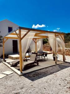 a gazebo with a table and chairs under it at Villa Voleonas-private pool & olive grove Chania in Kounoupidhianá