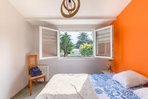 a bedroom with orange walls and a bed and a window at Maison, 150 m de la plage, la Tresson,Noirmoutier in La Guérinière
