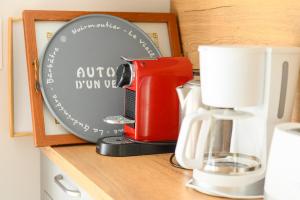 a red coffee maker on a shelf next to a plate at Maison, 150 m de la plage, la Tresson,Noirmoutier in La Guérinière