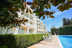 a building with a swimming pool next to a resort at Romance Studio-steps from theSea in Varna City