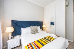 a bedroom with a large white bed with a blue headboard at Modern Executive Unit in East London +223 photos