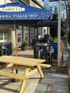 a picnic table with an umbrella in front of a restaurant at The Psalter in Sheffield
