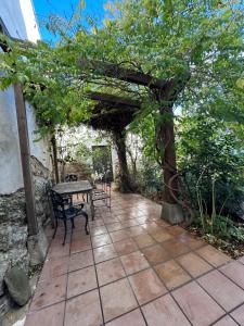 a patio with a table and chairs under a tree at Casa Rural La Tahona in Lerín +15 photos