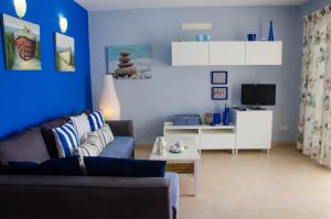 a blue living room with a couch and a tv at Mi casita de la playa in Arrieta