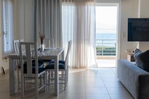 Un comedor con una mesa y sillas y un sofá. en Christo’s Beachfront Bliss, en Nafpaktos