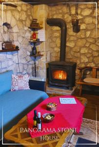 a room with a stove with a bed and a table at Panorama Stone Houses - Skadar Lake in Cetinje