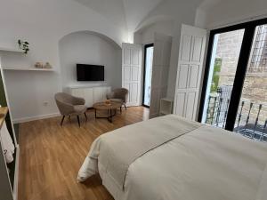 een slaapkamer met een bed, een tafel en een tv bij La Pata Suites in Trujillo +43 foto's