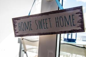 Una señal que dice hogar dulce hogar en una ventana en Mi casita de la playa, en Arrieta