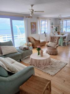 a living room with couches and a table at Sea Rose Cottage with Hot Tub in Dido Valley