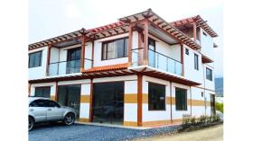 a house with a car parked in front of it at Apto 204 Apartahotel Los Pinos in Sáchica