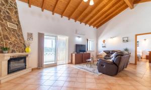 a living room with a couch and a fireplace at room in Casa VERANEAR in Aljezur