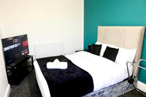 Schlafzimmer mit einem großen weißen Bett und einem Flachbild-TV in der Unterkunft Kyoto Central I 4 BDR House I 50 inch Smart TVs in Rooms I Large Spacious Rooms I Refurbished I Derby City Centre in Derby + 26 Fotos