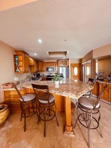 Rosarito BeachにあるDream Condo Pool, Jacuzzi, and Ocean Viewsのバースツール付きの大きな島のあるキッチンが備わります。