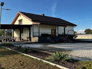 una piccola casa con portico e tavolo da picnic di Holiday Home in Stepnica by Szczecin Lagoon a Stepnica