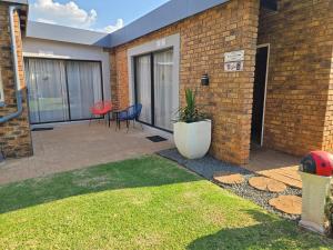 a house with a patio with chairs and a plant at Zhantique Guest House 2- Unit 3 in Boksburg +5 photos