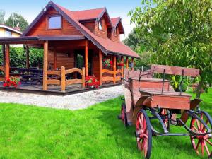 a wooden cabin with a wooden cart in front of it at Wooden House by Baltic Sea & Wolin Park in Międzyzdroje