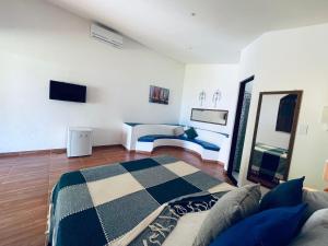 a living room with a bed and a couch at Alma Tropical Mini Resort in Vera Cruz de Itaparica