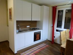 a kitchen with white cabinets and a sink at il 23 Holiday Home in La Spezia