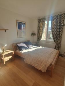 Ένα ή περισσότερα κρεβάτια σε δωμάτιο στο Cosy apartment with a magnificent view 10 min from Paris Exhibition Centre