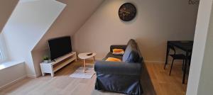 Votre Refuge Urbain Logement Complet pour Étudiants et Pros في فوجير: غرفة معيشة مع أريكة وتلفزيون