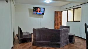 a living room with a couch and a chair and a tv at Departamento cómodo en Oruro in Oruro