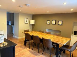 a dining room with a wooden table and chairs at Cosy Carnegie Cottage close to Dornoch Golf Course in Dornoch +25 photos