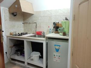 a small kitchen with a sink and a stove at Studio à Carthage Yasmina in Douar ech Chott +3 photos