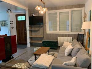 カンパンにあるAu bord du ruisseau - Campanのソファとテレビのあるリビングルーム