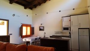 a kitchen with a couch and a table and a refrigerator at Apartamentos Rurales En Plena Sierra in La Calera