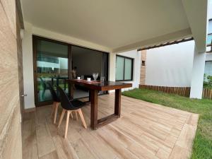 a wooden table and chairs on a patio at Itacimirim Beach Unique in Camacari
