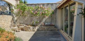 a patio with pink flowers on a stone wall at Pause couleur Lavandula in Roussas