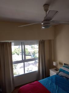 a bedroom with a ceiling fan and a window at Comfortable Apartamento Semi Piso in Buenos Aires