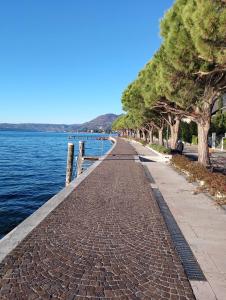 a brick sidewalk next to a body of water at Gardalba in Toscolano Maderno +17 photos