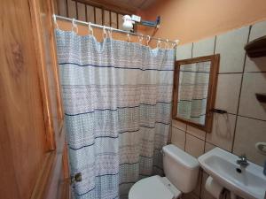 Un baño con inodoro y cortina de ducha. en Apartamentos Quepos Malichita Studio, en Quepos 12 fotos más