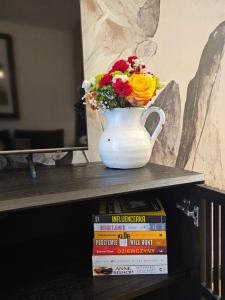 a vase filled with flowers sitting on top of books at F&R Sea Bliss Apartment in Gdańsk +33 photos