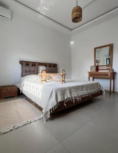 ein Schlafzimmer mit einem großen Bett und einem Spiegel in der Unterkunft Dar Mami in Al Maqārisah