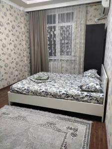 a bedroom with a bed and a window at Sun elit in Bishkek