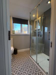 a bathroom with a glass shower and a toilet at Cosy Carnegie Cottage close to Dornoch Golf Course in Dornoch