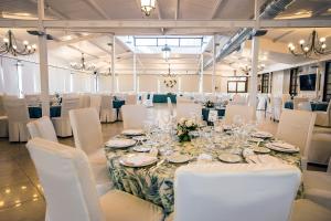 a room with a long table with white chairs and a room with white tables at Hotel Casa José Díaz in San Agustín de Guadalix