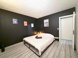 a bedroom with a bed and a black wall at Loft 49 in Le Mée-sur-Seine