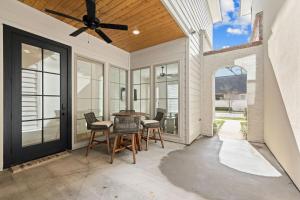 eine Terrasse mit Tisch und Stühlen und einem Deckenventilator in der Unterkunft NEW Lafayette House KING Beds Garage Patio Luxury in Lafayette