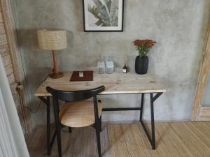 a desk with a chair and a lamp and a table at Sampian Cottages Bingin in Uluwatu