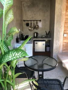 a table and chairs in a kitchen with a stove at Sampian Cottages Bingin in Uluwatu +3 photos
