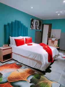 a bedroom with a large bed with red pillows at Reutlwane Gardens B&B in Secunda +194 photos