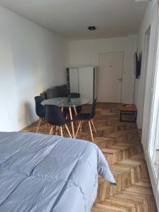 a bedroom with a bed and a table and chairs at Departamento monoambiente in La Plata