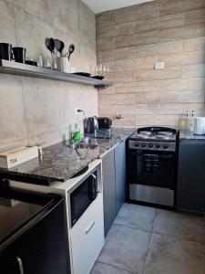 a kitchen with a stove and a counter top at Departamento monoambiente in La Plata