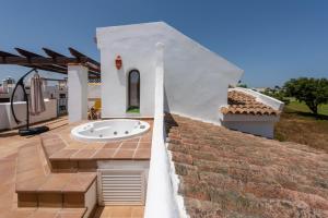 a white house with a bath tub on a patio at Casa adosada en campo de golf Alcaidesa Links in San Roque